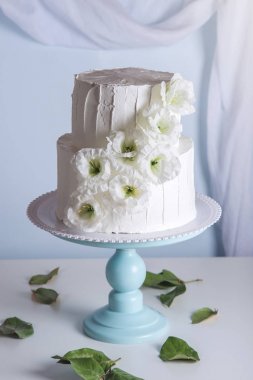 Beyaz ranza düğün pastası çiçeklerle süslenmiş
