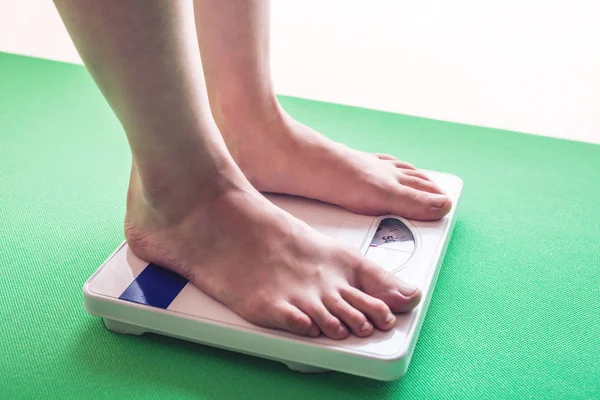 Female feet standing on mechanical scales for weight control. Concept of slimming and weight loss — Stock Photo, Image