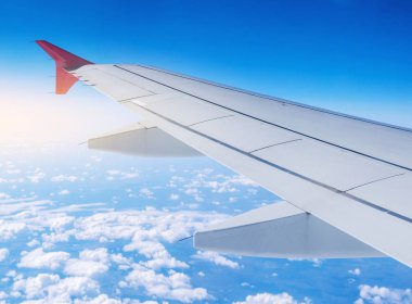 Uçak uçuş bulutlar bir arka plan üzerinde kanat. Kavramı