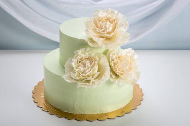 Güzel ev yapımı düğün pastası iki katmanlı bej güller ile dekore edilmiştir..