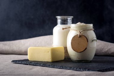 Eko çiftlik ürünleri süt, peynir, ekşi krema, koyu ahşap zemin üzerine yoğurt. Ev yapımı doğal gıda kavramı