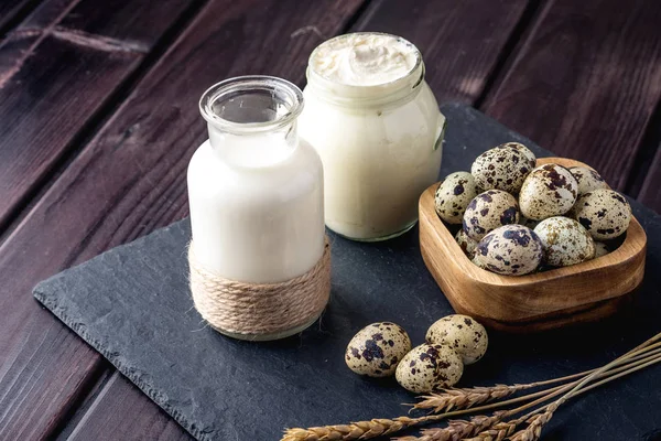 Eko çiftlik ürünleri süt, ekşi krema, yoğurt, koyu ahşap arka plan üzerinde yumurta. Ev yapımı doğal gıda kavramı