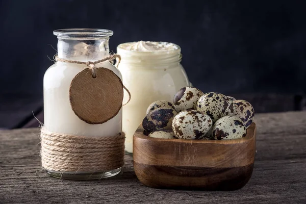 Eko çiftlik ürünleri süt, ekşi krema, yoğurt, koyu ahşap arka plan üzerinde yumurta. Ev yapımı doğal gıda kavramı