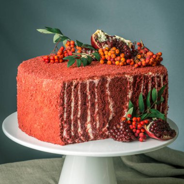 Güzel kadife kek rowan ve ahşap bir masa üzerinde Nar ile üst süslenmiş. Tatlı sonbahar natürmort kavramı