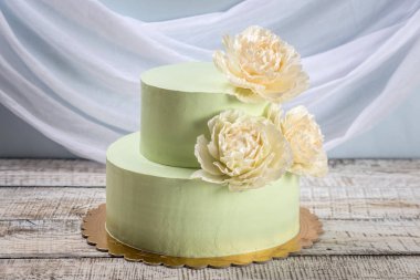Güzel ev yapımı düğün pastası iki katmanlı bej güller ile dekore edilmiştir..