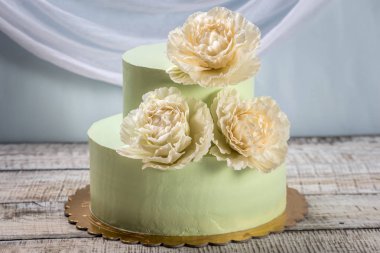 Güzel ev yapımı düğün pastası iki katmanlı bej güller ile dekore edilmiştir..
