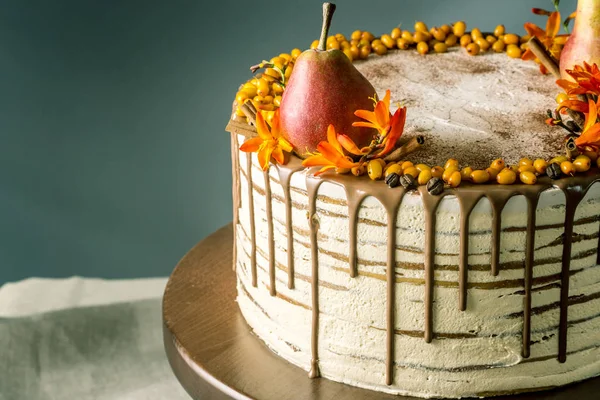 Pastel de miel verter sobre el chocolate y decorado con peras y espino cerval de mar sobre una mesa de madera. Dulce naturaleza muerta de otoño —  Fotos de Stock