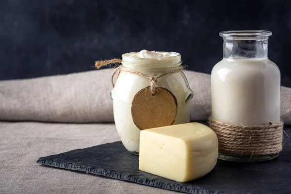 Eko çiftlik ürünleri süt, peynir, ekşi krema, koyu ahşap zemin üzerine yoğurt. Ev yapımı doğal gıda kavramı