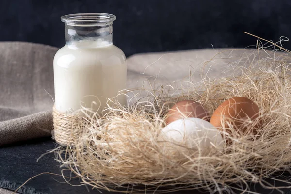 Eko çiftlik ürünleri süt, yoğurt, koyu ahşap arka plan üzerinde yumurta. Ev yapımı doğal gıda kavramı