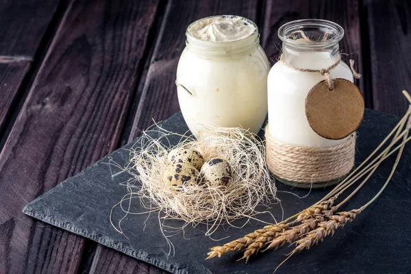 Eko çiftlik ürünleri süt, ekşi krema, yoğurt, koyu ahşap arka plan üzerinde yumurta. Ev yapımı doğal gıda kavramı