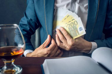 Takım elbiseli adam işadamı cebine para koyar. Euro faturaları şeklinde bir rüşvet. Yolsuzluk ve rüşvet kavramı