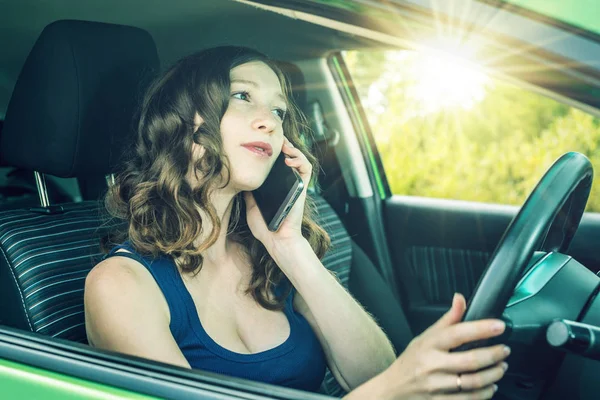 Arabada bir telefonda konuşurken kadını sürücüsü. Dalgın ve tehlikeli sürüş. Trafik ihlali.