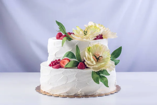 首页婚礼两层蛋糕装饰着黑醋栗、 草莓和黄色的花。节日的浆果甜点 — 图库照片