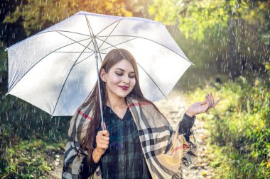 Mutlu genç kadın yağmur altında beyaz bir şemsiye ile Sunny Park'ta yürüyordunuz. Mevsim ve sonbahar ruh kavramı