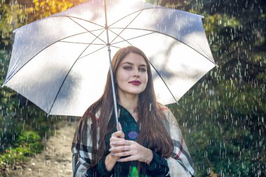 Mutlu genç kadın yağmur altında beyaz bir şemsiye ile Sunny Park'ta yürüyordunuz. Mevsim ve sonbahar ruh kavramı
