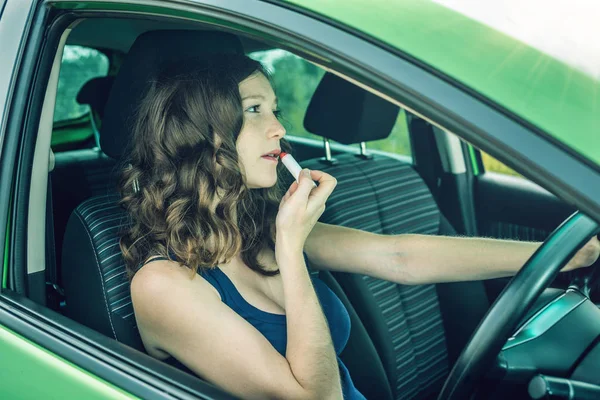 Sürücü kadın ayna ve araba ruj arıyorum. Dalgın ve tehlikeli sürüş. Trafik ihlali