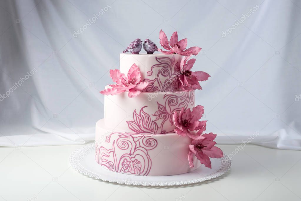 A beautiful home wedding three-tiered cake decorated with pink flowers