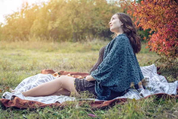 Bir mide ile bekleyen anne battaniye üzerinde oturur ve bebeğe anlatır. Gebelik ve sonbahar uyum kavramı — Stok fotoğraf