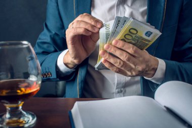 Takım elbiseli adam işadamı cebine para koyar. Euro faturaları şeklinde bir rüşvet. Yolsuzluk ve rüşvet kavramı