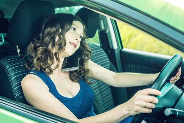 Arabada bir telefonda konuşurken kadını sürücüsü. Dalgın ve tehlikeli sürüş. Trafik ihlali.