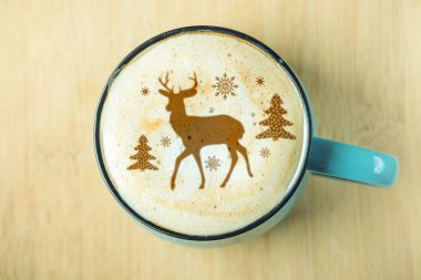 Sevimli kış desen üzerinde süt köpüğü cappuccino kahve bir fincan. Mutlu Noeller