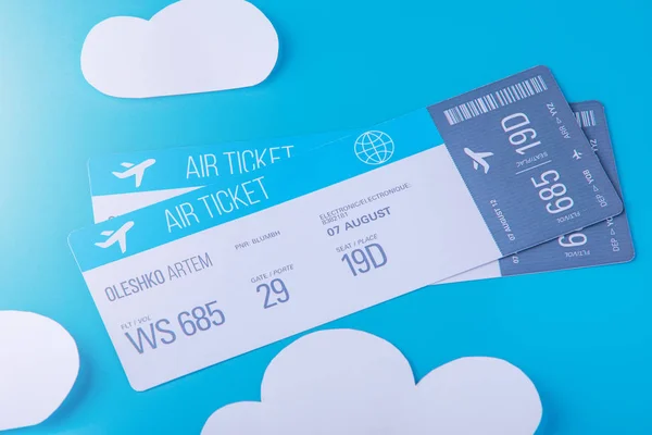 Two ticket for a plane on a background of blue sky with paper clouds. Concept travel and online booking