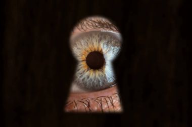 Male blue eye looking through the keyhole. Concept of voyeurism, curiosity, Stalker, surveillance and security clipart