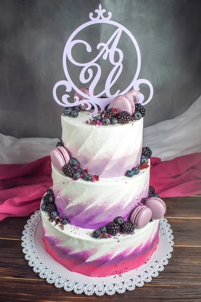Hermoso delicioso pastel de boda de tres niveles decorado con bayas arándanos y moras en color rosa púrpura —  Fotos de Stock