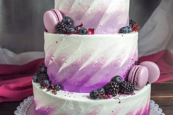 Hermoso delicioso pastel de boda de tres niveles decorado con bayas arándanos y moras en color rosa púrpura —  Fotos de Stock