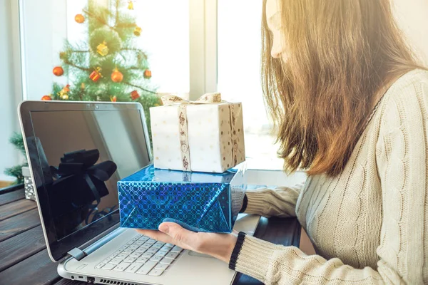 Donna che tiene un regalo per Natale e prenotazione di anno nuovo sopra l'Internet nel computer portatile. Concetto di vendita di vacanze — Foto Stock