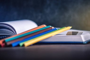 Okul gereçleri masanın üzerinde. Kitaplar ve kalem öğrenci topluluğu var. Okul ve eğitim kavramı