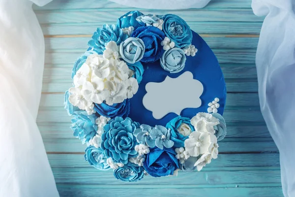 Beautiful blue wedding cake decorated with white flowers of cream. Concept of Holiday desserts for a birthday