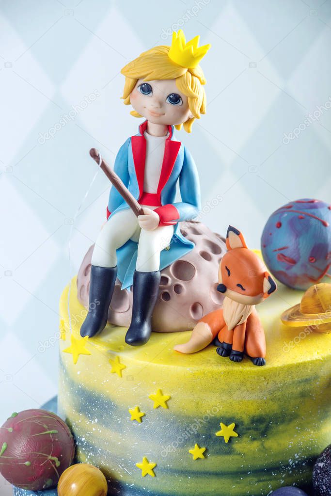 Big kids beautiful cake decorated in the form of the planet with the mastic figurines of the little Prince and the Fox