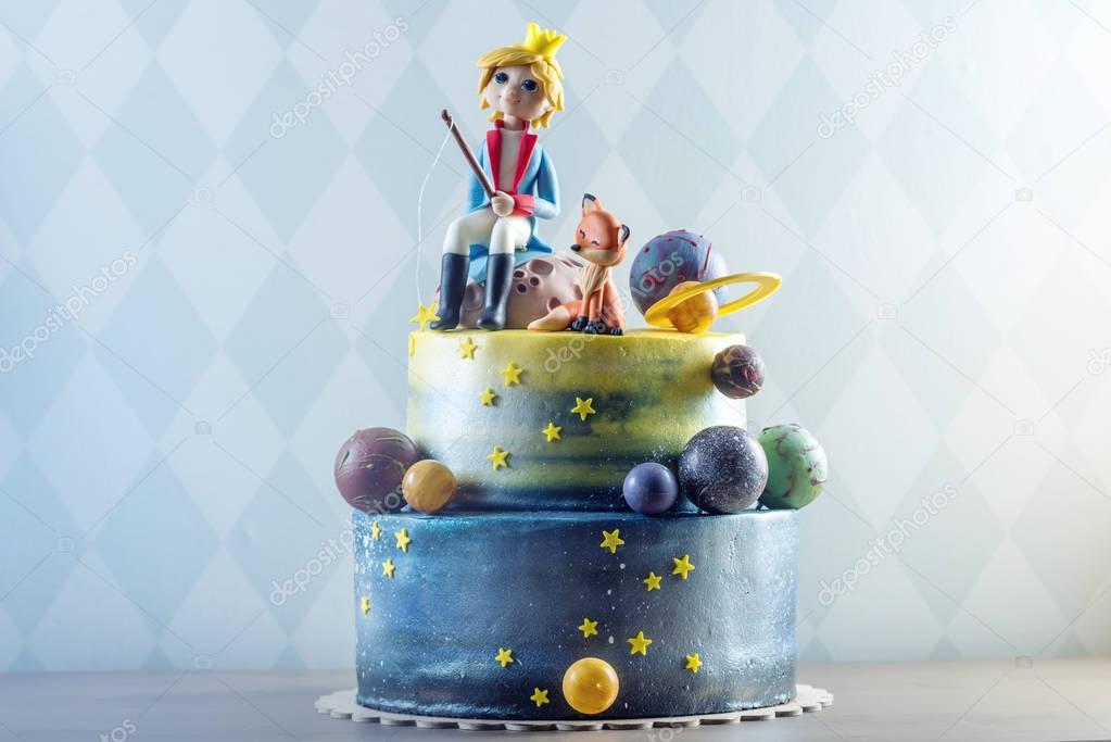 Big kids beautiful cake decorated in the form of the planet with the mastic figurines of the little Prince and the Fox