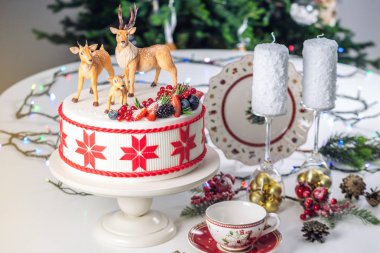 Geyik ve şenlikli bir tablo taze çilek mastik rakamlar beyaz Noel kek üstüne kırmızı süsleme ile süslenmiş