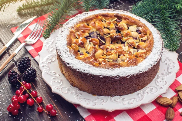 Tarte aux baies maison de Noël ou du Nouvel An avec des noix sur fond de table en bois. Concept de desserts festifs — Photo