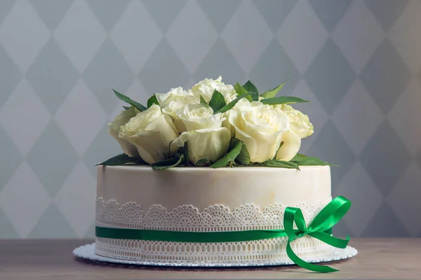 美丽的白色婚礼蛋糕装饰着花束白花白玫瑰。典雅假日甜点的概念 — 图库照片