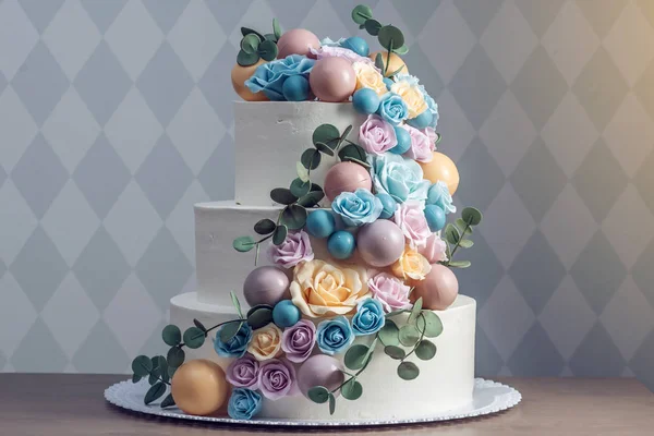 Gyönyörű három rétegű fehér esküvői torta díszített színes virágok Rózsa. Az elegáns holiday desszertek koncepció — Stock Fotó
