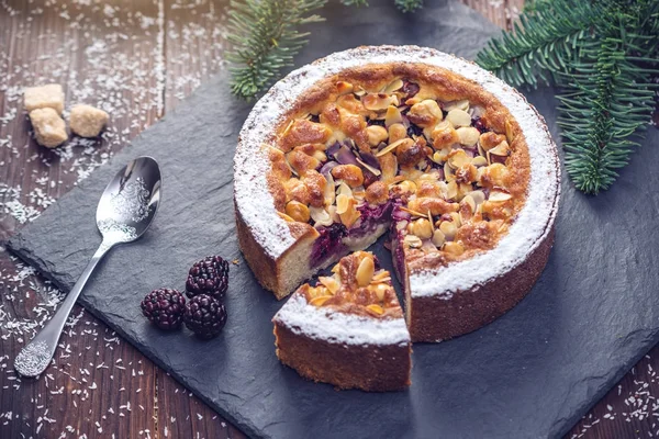 Домашний рождественский или новогодний ягодний пирог с орехами на деревянном столе. Концепция праздничных десертов — стоковое фото
