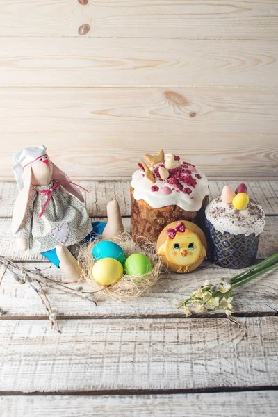Праздничный стол с тортом и красочными яйцами на деревянном фоне. Концепция православной Пасхи — стоковое фото