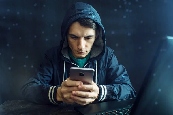 Peretas pria menggunakan ponsel untuk meretas sistem. Konsep kejahatan cyber dan peretasan perangkat elektronik — Stok Foto