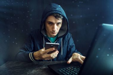 Erkek hacker cep telefonu sistemi kesmek için kullanır. Siber suç ve elektronik cihazlar kesmek kavramı