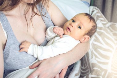 Yatak odasında erkek gülümseyen bir bebek tutan mutlu bakım anne. Annelik ve aile değerleri hassasiyet kavramı