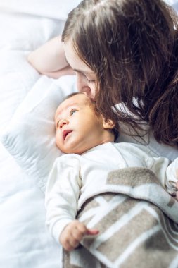 Mutlu erkek gülümseyen bir bebek tutan anne ve onu öper. Annelik ve aile değerleri hassasiyet kavramı