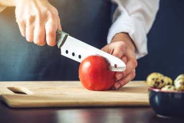 Siyah önlük Şef sebze keser. Yemek pişirmek için çevre dostu ürünler kavramı