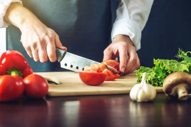 Siyah önlük Şef sebze keser. Yemek pişirmek için çevre dostu ürünler kavramı