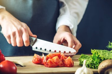 Siyah önlük Şef sebze keser. Yemek pişirmek için çevre dostu ürünler kavramı