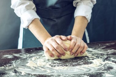 Siyah önlük Şef pizza hamuru ellerini masaya sağlar.