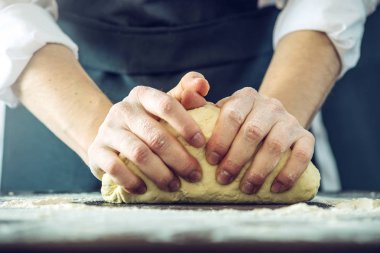 Siyah önlük Şef pizza hamuru ellerini masaya sağlar.