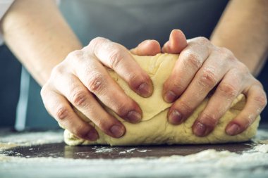 Siyah önlük Şef pizza hamuru ellerini masaya sağlar.